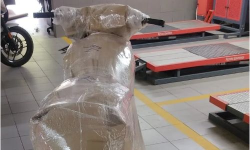 A Royal Enfield motorcycle meticulously protected with multi-layer bubble wrap and paper packaging by euro packers and movers in kolkata team.
