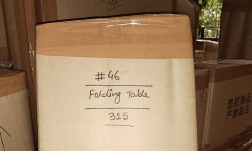 Sealed household goods and carton boxes stacked in an apartment lobby by packers and movers during a residential shift