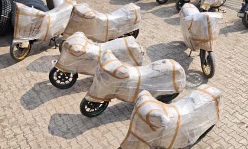 Multiple two-wheelers bubble-wrapped and lined up for safe bike transit services by professional packers movers kolkata.