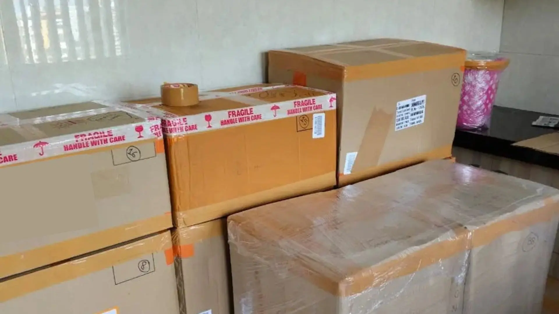 Professional packers and movers packing household goods during a 3 BHK apartment relocation from Salt Lake to New Town Kolkata with secure bubble wrapping and carton packing.